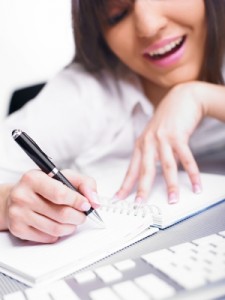 image of woman happily writing